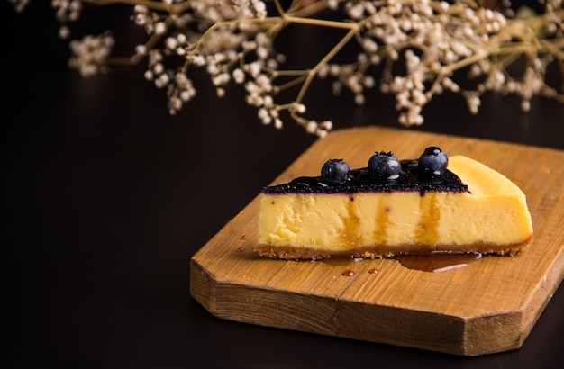 Cheesecake with blueberries on a black background. Copy space