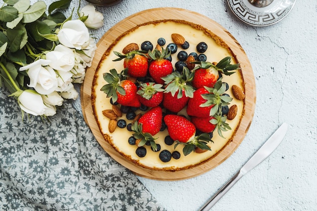 Cheesecake with blueberries strawberry almond on the white concrete background with napkin