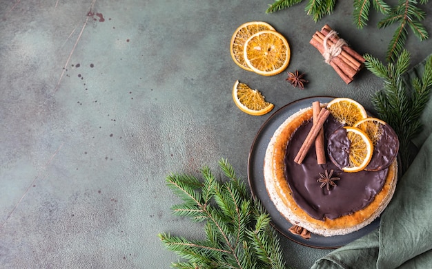 Cheesecake with chocolate decorated slices of dried oranges cinnamon and anise