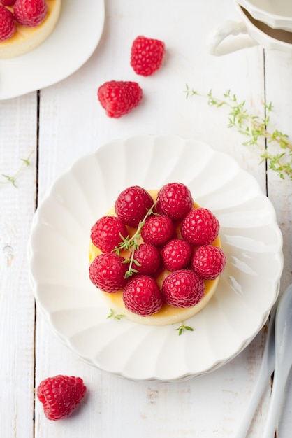 Cheesecake with fresh raspberries on a white plate