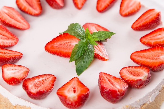 Cheesecake with strawberries and mint on a table with a light tablecloth Sweet homemade breakfast Copy space