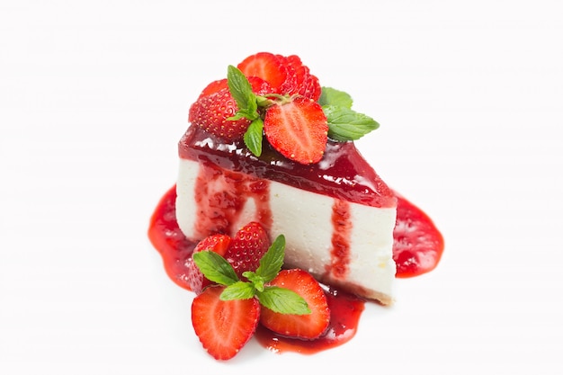 Cheesecake with strawberry jelly and jam, berries, mint leaves isolated