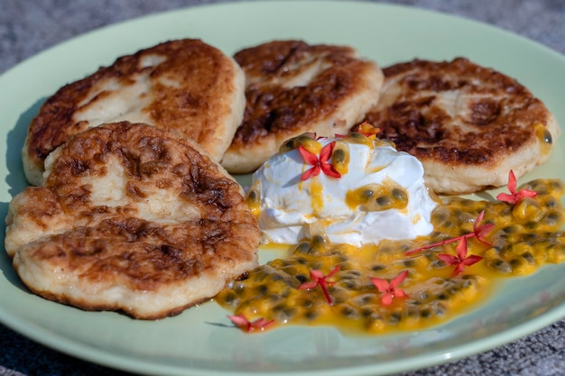 Cheesecakes with passion fruit and sour cream in a green plate for breakfast Delicious dessert closeup