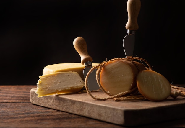 Cheeses scene with different cheeses and accessories over rustic wood selective focus