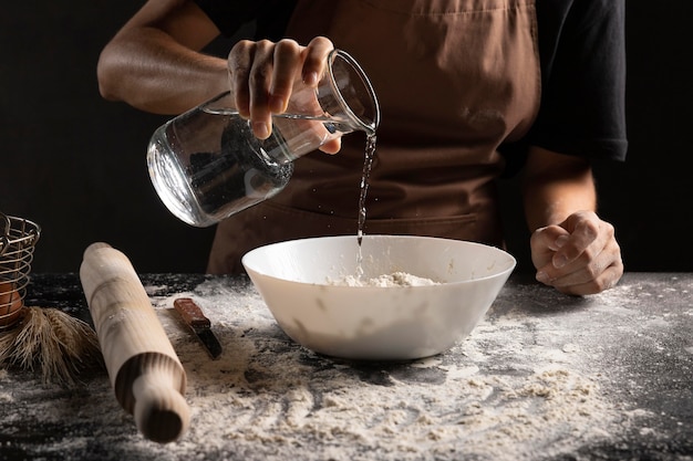 Chef adding water to mix for creating dough