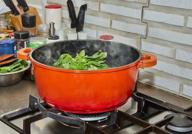 Chef blanched bunch of basil in simmering pot