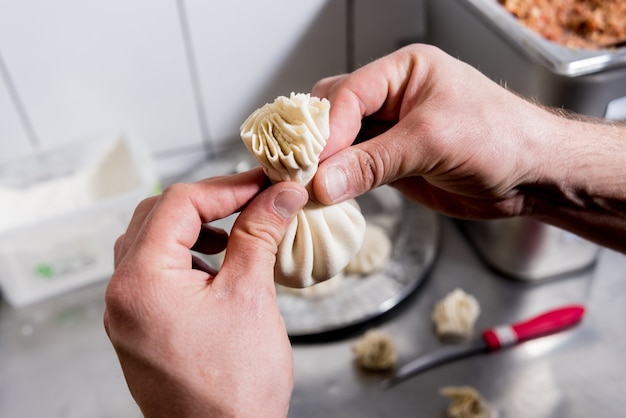 Chef coocking georgian khinkali or japanese wonton. Traditional meal