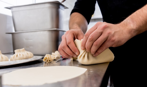 Chef coocking georgian khinkali or japanese wonton