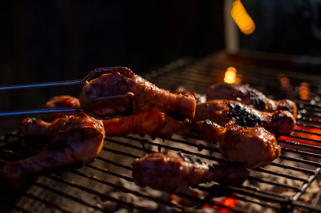 Chef cooking jerk barbecue BBQ chicken on the grill hand turning food. grilled meat