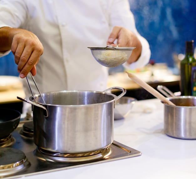 Chef cooking spaghetti in the kitchen