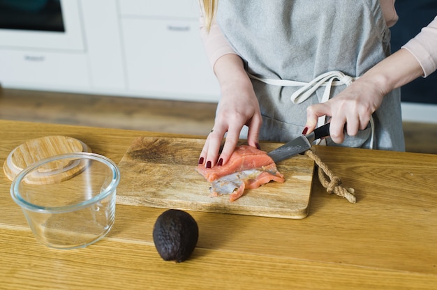 The chef cuts Atlantic salmon for a sandwich with avacado and egg. 