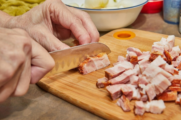 Chef cuts bacon in the kitchen for recipe