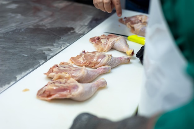 A chef cuts chicken on a cutting board