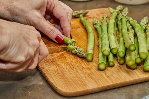 Chef cuts the heads off the asparagus to prepare the dish