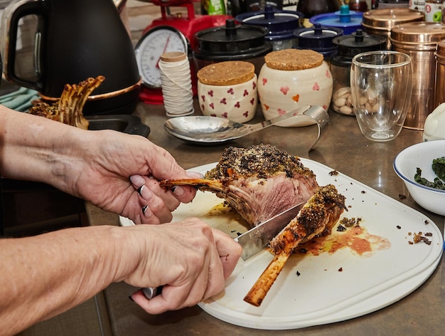 Chef cuts Lamb ribs with garlic and mustard sauce after baking in the oven