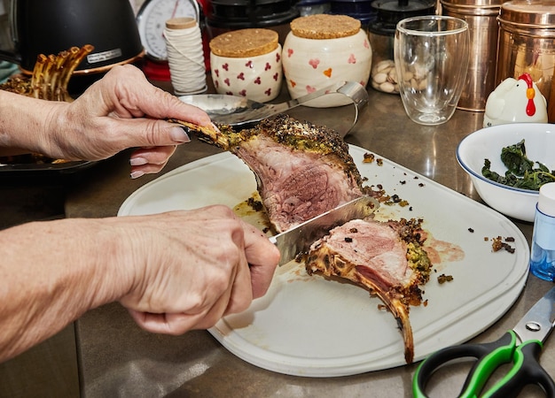 Chef cuts Lamb ribs with garlic and mustard sauce after baking in the oven