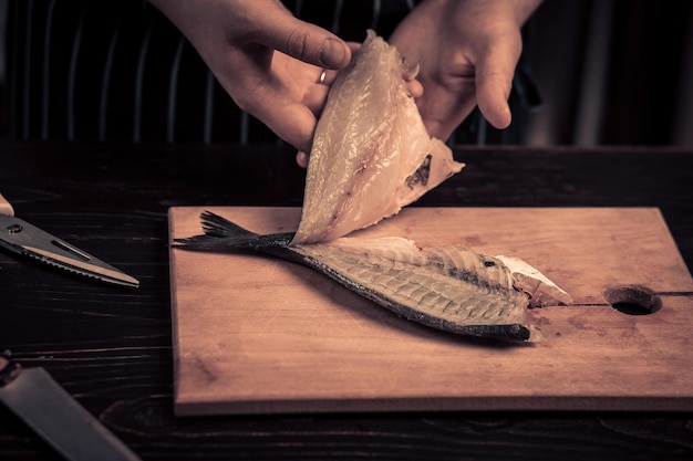 Chef cutting the fish on a board