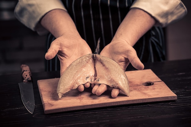 Chef cutting the fish on a board