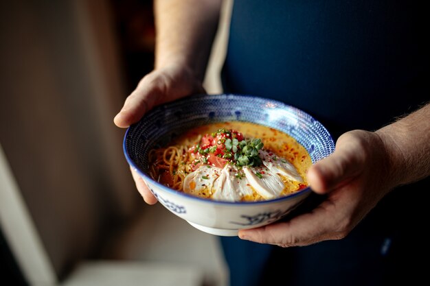 Chef holding bowl of japanese curry chicken ramen