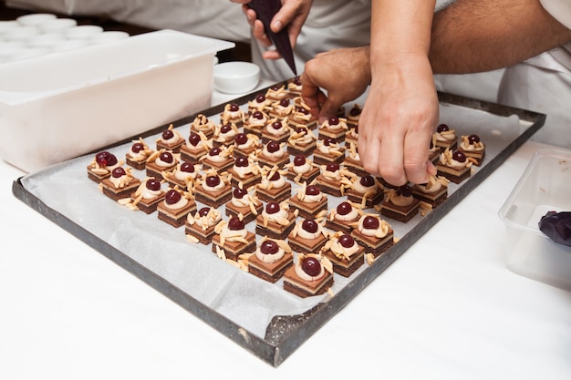 Chef in hotel or restaurant kitchen making dessert for dinner