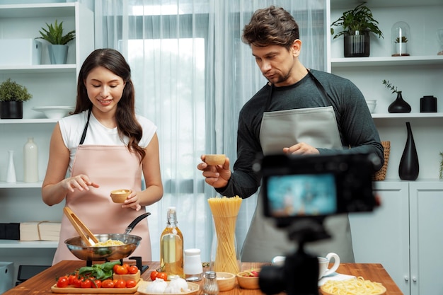 Chef influencers cooking special spaghetti with tongs to fried pan Postulate