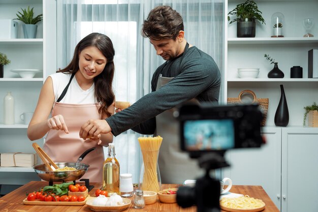 Chef influencers cooking special spaghetti with tongs to fried pan postulate