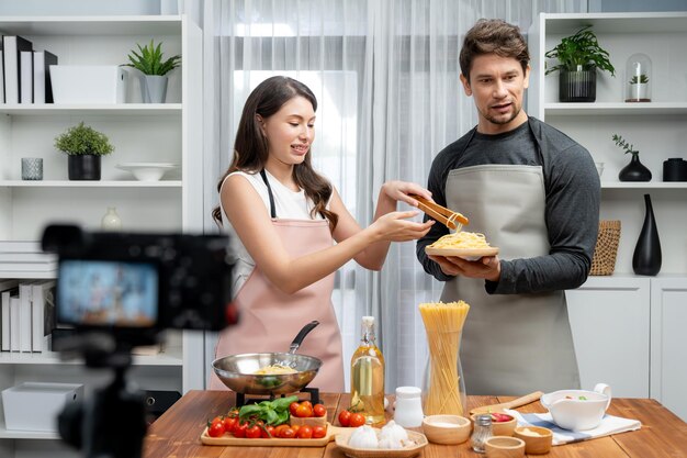 Chef influencers cooking special spaghetti with tongs to fried pan Postulate