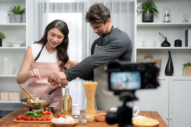 Chef influencers cooking special spaghetti with tongs to fried pan Postulate