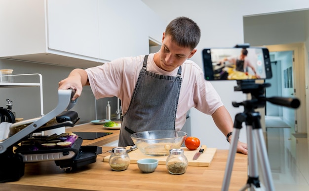 The chef is broadcasting live from workshop how to prepare a grilled eggplants with garlic