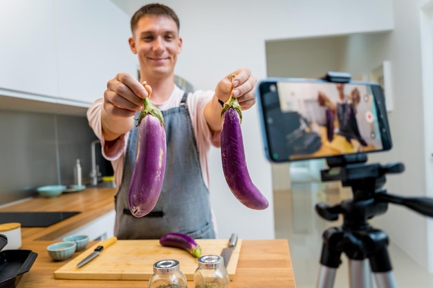 Photo the chef is broadcasting live from workshop how to prepare a grilled eggplants with garlic