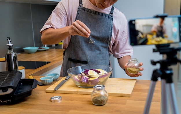 Photo the chef is broadcasting live from workshop how to prepare a grilled eggplants with garlic