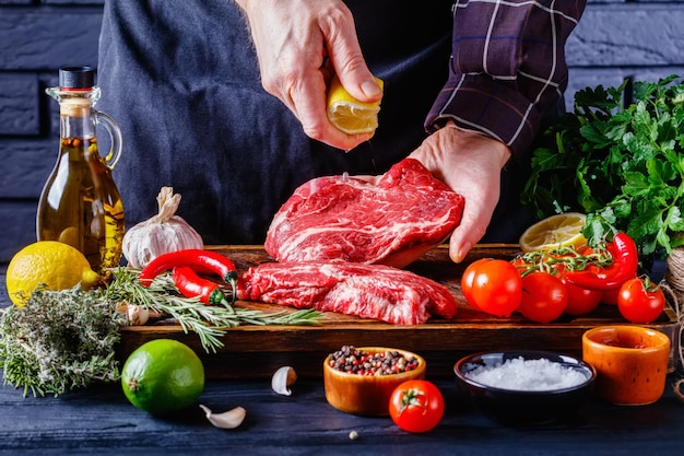 Chef is sprinkling the lemon juice over beef steak