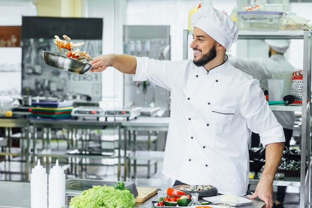 Chef juggling with vegetables and other food in the kitchen