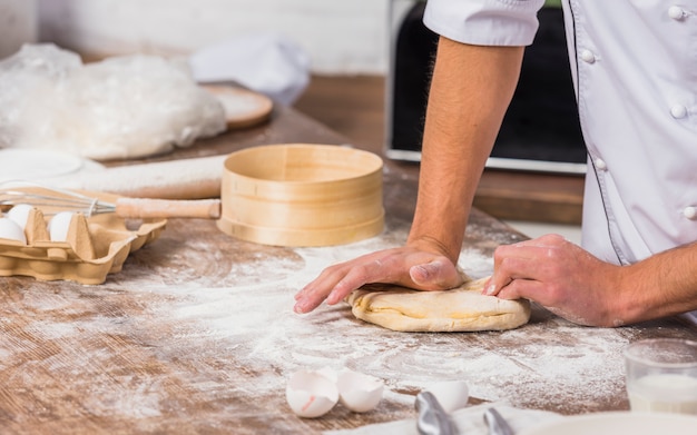 Chef in kitchen making dough