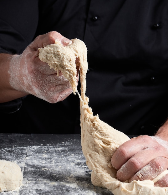 Chef kneads dough made of white wheat flour 