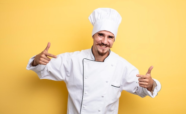 chef man smiling confidently pointing to own broad smile