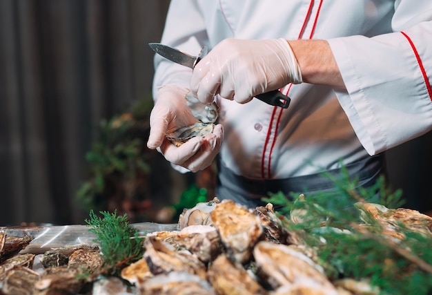 The chef opens oysters in the restaurant.