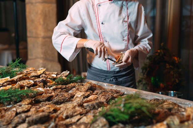 Photo the chef opens oysters in the restaurant