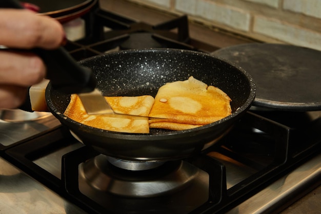 Chef panfrying Crepe Suzette pancakes with cognac and citrus sauce