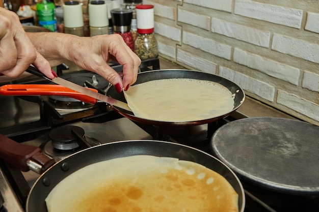 Chef panfrying Crepe Suzette pancakes with cognac and citrus sauce