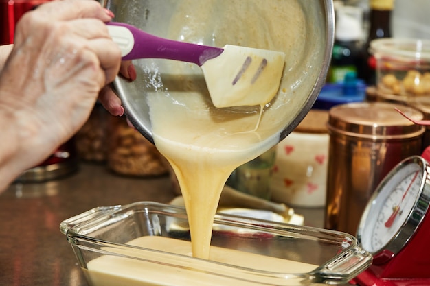 The chef pours the finished dough into mold for making cherry pie, clafoutis. Step by step recipe.