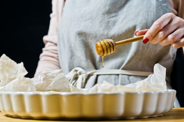 The chef pours honey slices of bananas in a baking dish. Cooking fried bananas. 