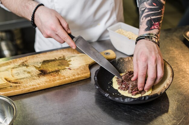 Chef prepares beef steak tenderloin in the restaurant kitchen