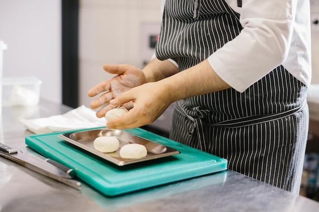 The chef prepares cheese pancakes in the kitchen of the cafe