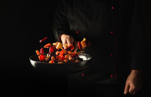 The chef prepares fresh vegetables in a frying pan Recipe for healthy vegetarian food