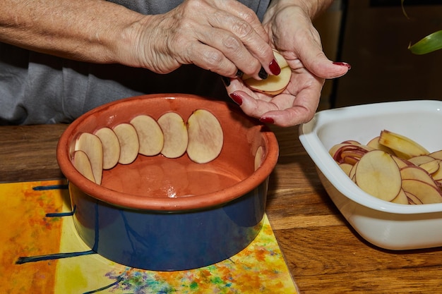 Chef prepares potato gratin in flowershaped ceramic dish