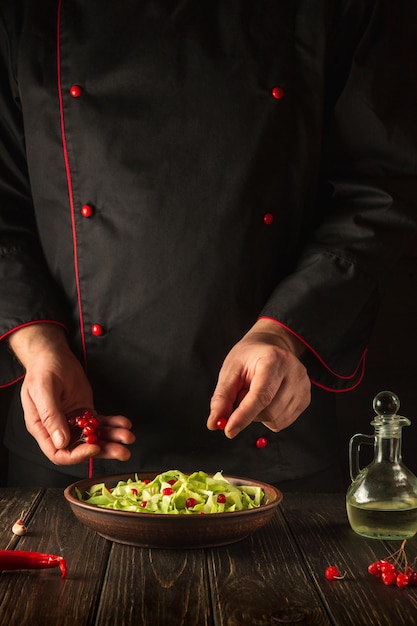 The chef prepares a salad for breakfast or lunch in the kitchen