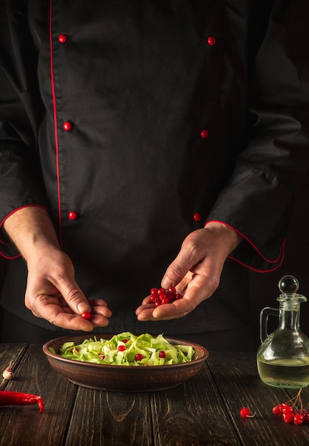 The chef prepares a salad for breakfast or lunch in the kitchen