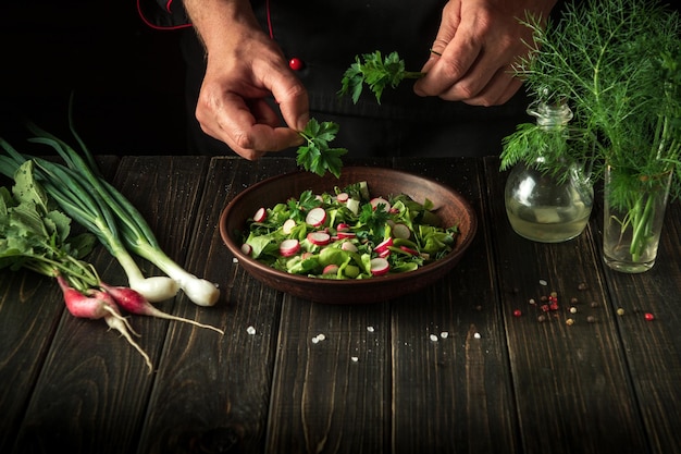 The chef prepares a salad of fresh vegetables