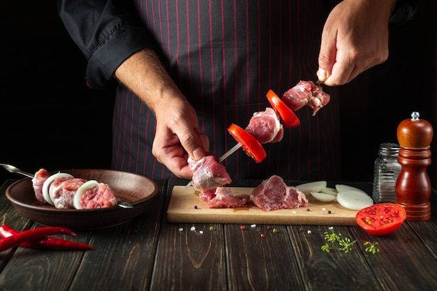 The chef prepares shish kebab from fresh sliced beef meat Traditional oriental dish barbecue